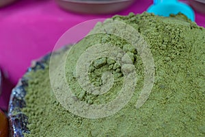 Container with green mole powder. photo
