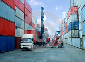 Container handlers put containers into work trucks in the harbor