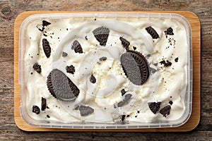 Container of ice cream with chocolate sandwich cookies