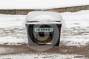 container with the inscription sand. It is sand to sprinkle the ice on street.