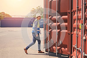 container logistic operators workers wearing yellow helmets and reflection shirts and open containers for inspection and check the