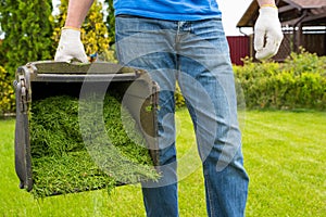 A container of mowed grass and a worker close-up. Housework