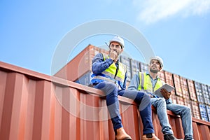 Container operators wearing helmets and safety, vests control via walkie-talkie workers in container yards. Cargo Ship Import