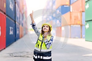 Container operators women wearing helmets and safety vests control via walkie-talkie workers in container yards. Cargo Ship Import