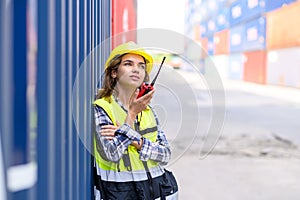 container operators women wearing helmets and safety vests control via walkie-talkie workers in container yards. Cargo Ship Import