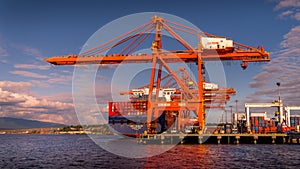 Container Port with the Large Container Cranes loading a Ocean Going Freighter in Vancouver Harbor