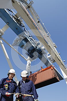 Container port, workers, cranes and trucks