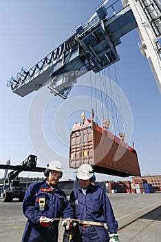 Container port, workers, cranes and trucks