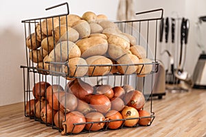 Container with potatoes and onions on kitchen counter. Orderly storage