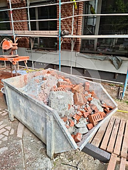 A container with rubble in front of a construction site