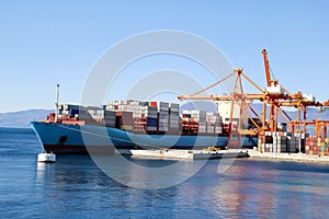 Container ship for carriage of goods with containers to shore in port ship port on horizon.