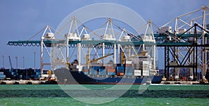 Container ship in commercial port with containers