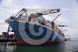 Container ship docked in port unloading cargo.