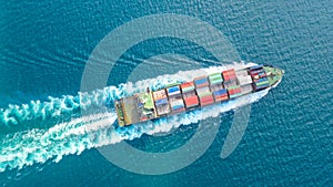 Container ship in export and import business and logistics. Shipping cargo to harbor by crane. Water transport International.