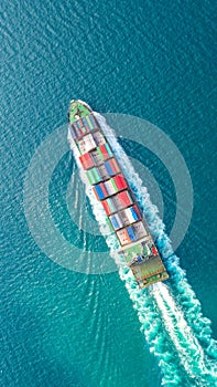 Container ship in export and import business logistics and transportation. Cargo and container box shipping to harbor by crane.