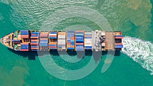 Container ship in export and import business logistics and transportation. Cargo and container box shipping to harbor by crane.