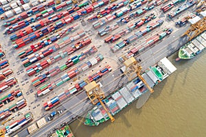 Container ship in import export tradeport top view from drone