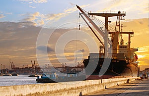 Container ship loading material goods from local ship in habor p