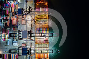 Container ship loading and unloading in deep sea port, Aerial view at night