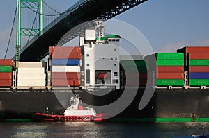 Container ship and red tugboat photo