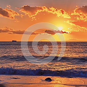 Container ship silhouetted against the sunset in Tokyo bay, as seen from Chiba coastline