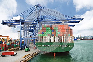 Container Ship in terminal working with shore crane at dock