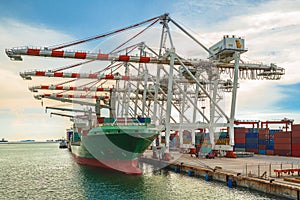 Container Ship in terminal working with shore crane at dock