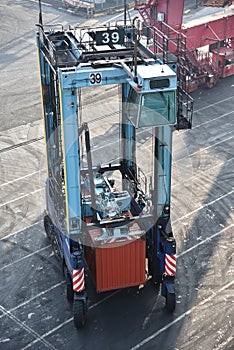 A straddle carrier delivering container to the gantry crane. photo