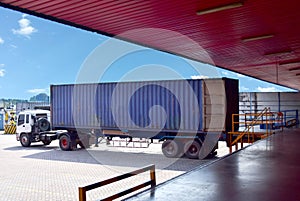 Container truck align with dock leveller at distribution warehouse for stuffing cargo