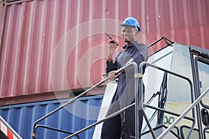 Container Worker hold Walkie Talkie on his Hand on the Cargo Crane Llifting Truck