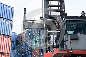 Container Worker hold Walkie Talkie on his Hand on the Cargo Crane Llifting Truck