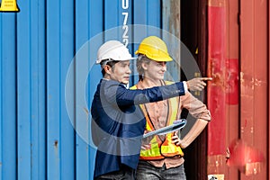 Container yard manager talking to female foreman about the goods inside the warehouse while shipping