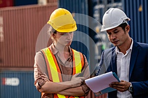 Container yard manager talking to female foreman about the goods inside the warehouse while shipping