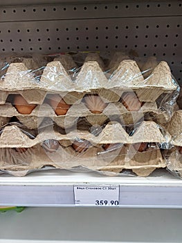 Containers with chicken eggs on a shelf in a store.