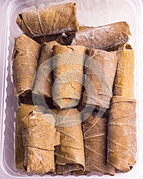 Containers with frozen  semi-finished meat products  from the refrigerator. dolma in grape leaves