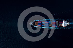 Containers ship corgo logistic transportation sailing top speed in dark sea Photograph aerial top view from drone point view at photo