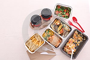Containers with tasty takeout meals on light background, top view. Food delivery photo