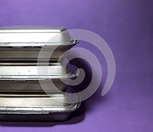 Containers To Go. Silver Container on a Purple Background