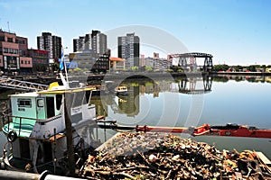 Contaminated river full of garbage, Riachuelo River. Old boat and dirty water arround photo