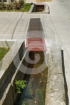 Contaminated water, sewage waste is drained through pipe into sea on an unequipped beach. Pollution of environment, ecological cat