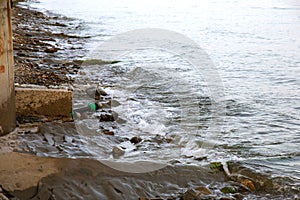 Contaminated water, sewage waste is drained through pipe into sea on an unequipped beach. Pollution of environment, ecological cat