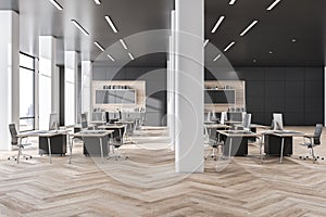 Contemorary grey coworking office interior with wooden flooring, daylight and city view. Business interiors concept.
