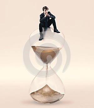 Contemplate on hourglass. Concept of taking a decision until the deadline.