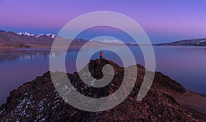 Contemplating Beauty: Mongolia, Alpine Lake Tolbo-Nuur 2079 M., Art Photography.Man In Red Jacket Standing On Red Rock And Photo