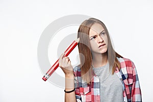 Contemplating girl scratching her head with big pencil