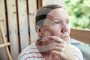 Contemplative adult female thinking and looking into distance in summer morning