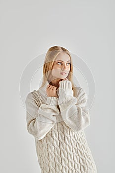 contemplative blonde woman in white warm