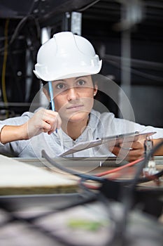 contemplative female worker in confined roof space