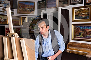 Contemplative male artist focused on painting his picture