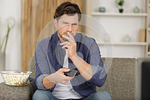contemplative man holding remote control